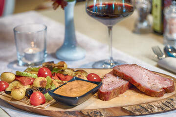 Grilled beef tenderloin with roasted vegetables and sauce served with red wine