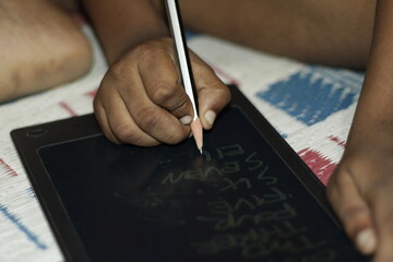 Portrait of a young boy using a stylus to draw on a digital screen, highlighting the importance of...
