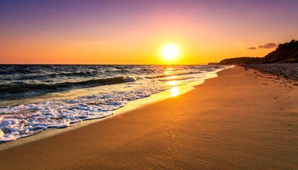 Obraz premium Coastal sunset painting sea and sand in golden light, creating a serene atmosphere with dark trees in the distance