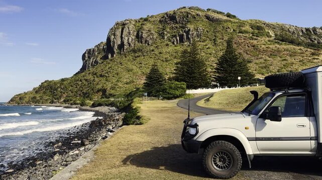 vehicle parked at the rock formation called the nut at Stanley along the rough and rugged coastline of Tasmania, a refuge and breeding area for little penguins, Eudyptula minor, Australia.