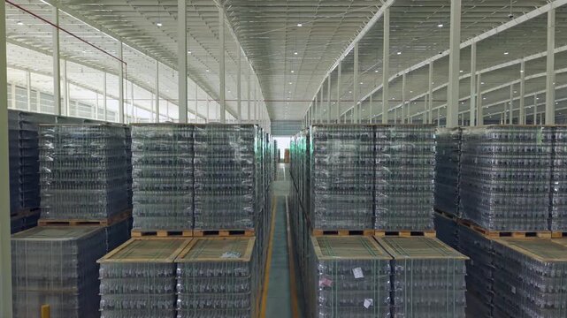 Storage warehouse with many pallets. Aerial rising shot. Sunny day outside. Brewery Plant factory in hato Nuevo.