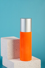 Skin care or sunscreen cosmetic with stylish props on blue background.