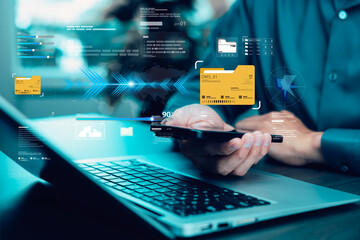 Person using smartphone and laptop with virtual data transfer interface and cloud storage icons. Concept of digital business, file sharing, data management, and modern technology.
