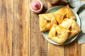 Puff pastry patties with mushroom and cheese filling on a rustic background. Top view.