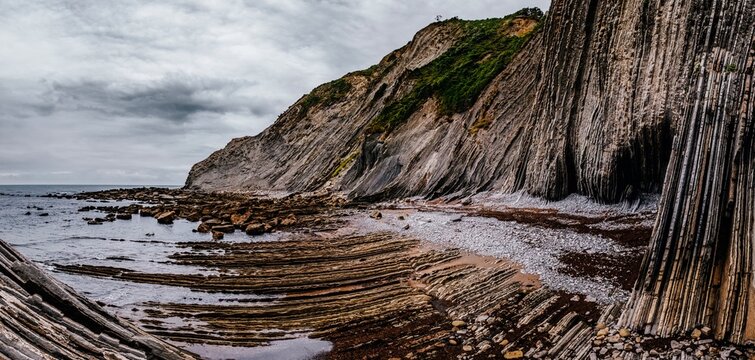 Layered Flysch Cliffs and Rock Formations at Low Tide on Itzurun Beach in Zumaia, Basque Country, Spain