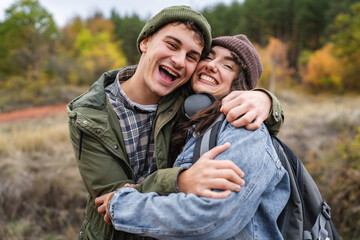 Happy young couple embracing outdoors on an autumn hike