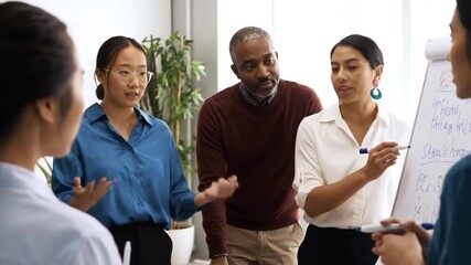 A diverse group of business professionals collaborating during a meeting in a modern office, with one woman writing on a flip chart. - Powered by Adobe