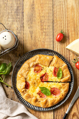 Crispy tomato galette with adyghe cheese and herbs on rustic background. Top view.