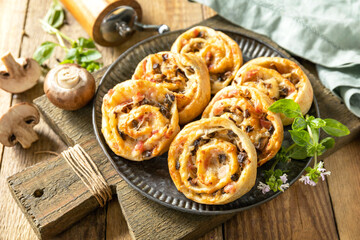 Puff pastry rolls with mushroom and cheese filling on rustic background.