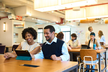 Diverse business team collaborating on tablet in modern office