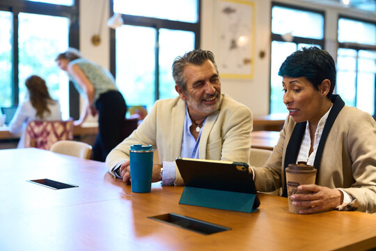 Business colleagues collaborating on tablet during office meeting