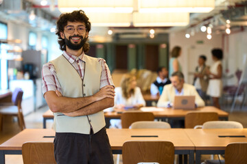 Professional man smiling, arms crossed in office
