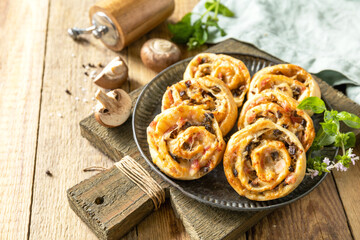 Puff pastry rolls with mushroom and cheese filling on rustic background.