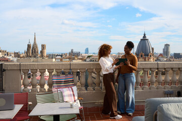 Women collaborating on tablet at barcelona rooftop coworking