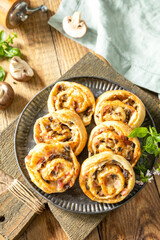 Puff pastry rolls with mushroom and cheese filling on rustic background.