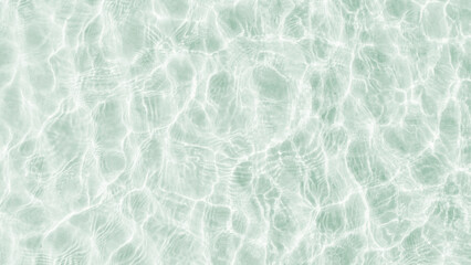 A background of clear water over a sandy bottom. Shallow water with white sand. Gentle ripples on the surface. Glittering reflections on the sea.