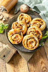 Puff pastry rolls with mushroom and cheese filling on rustic background.