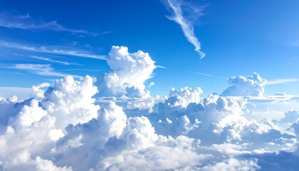 Expansive blue sky filled with fluffy cumulus clouds, some casting soft shadows below