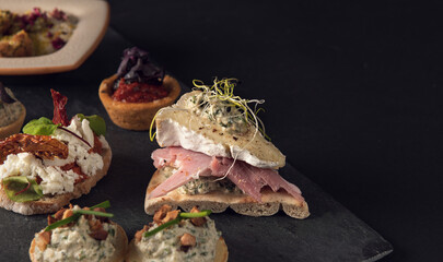 Assorted gourmet canapes on slate board close-up
