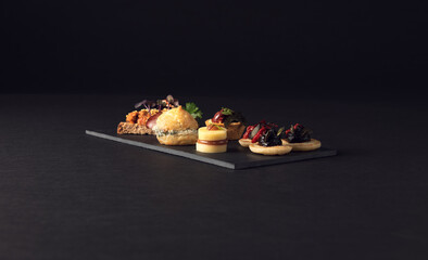 Refined platter of assorted canapes on slate board