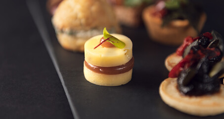 Mini blinis with black tapenade and roasted red pepper