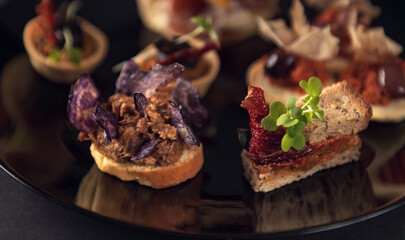 Close-up gourmet toast with purple chips and meat spread