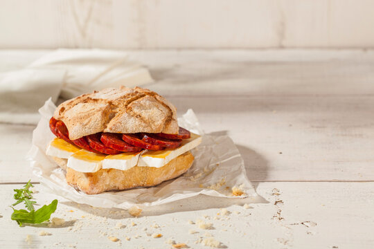 Ciabatta bread sandwich with brie cheese and a sausage made with pork and paprika.
