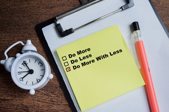 Concept of do more with less write on sticky notes isolated on Wooden Table.