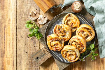 Puff pastry rolls with mushroom and cheese filling on rustic background. Top view.
