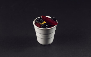 Elegant berry dessert cup on black surface