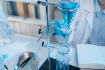 A chemistry researcher in a laboratory surrounded by scientific equipment and test tubes, representing innovation, scientific development, and modern medical research environment.