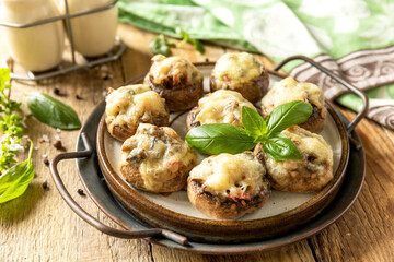 Stuffed mushrooms baked with cheese on rustic background.