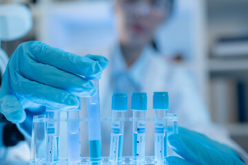 A chemistry researcher in a laboratory surrounded by scientific equipment and test tubes, representing innovation, scientific development, and modern medical research environment.