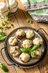 Stuffed mushrooms baked with cheese on rustic background.