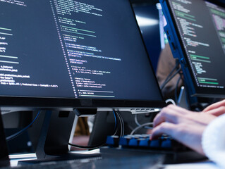 Close-up of Software developer hand typing on keyboard, writing code, developing app at tech office. Female computer programmer working on desktop computer development ai machine learning prompt.
