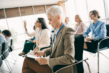 Diverse group of professionals collaborating during a business seminar in a modern office space.