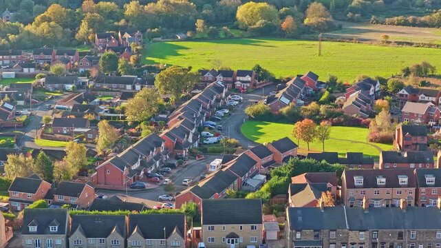 Hemingfield village showing rows of brick houses, curved streets, and surrounding green fields and woodland in South Yorkshire, England, static drone footage.