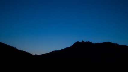 A majestic mountain silhouette against a twilight sky, radiating calm and natural beauty.