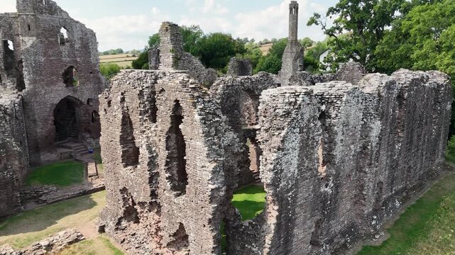 Detailed close rising drone footage of the majestic ruins of Grosmont Castle featuring main hall and tower with views over the Welsh Border on sunny summer day