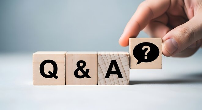 Hand placing a question mark block to complete q and a on wooden cubes