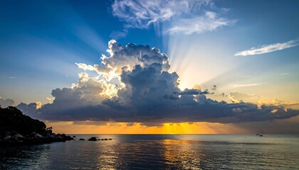 Golden sunlight beams through a large cloud over the calm ocean, illuminating the water's surface near a dark shore