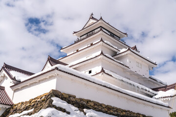 Tourist views snowy Japanese castle from balcony. Winter sightseeing