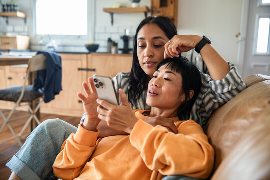 Young lesbian couple using a phone