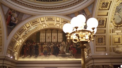Ornate historical interior with grand arch fresco and warm chandelier light creating elegant cultural atmosphere showing detailed classical art architecture heritage and museum appreciation mood