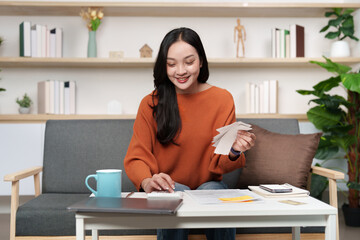 Tax preparation. Smiling woman organizing tax documents at home.