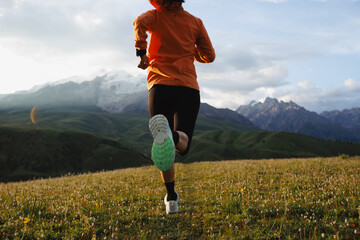 Trail runner running on the high altitude grassland mountain top