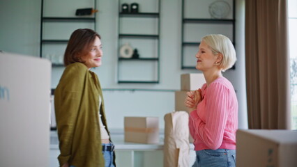 Girls examining new apartment hugging closeup. Lgbt couple house relocation