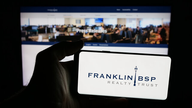Stuttgart, Germany - 10-30-2025: Person holding mobile phone with logo of US company Franklin BSP Realty Trust Inc. on screen in front of web page. Focus on phone display.