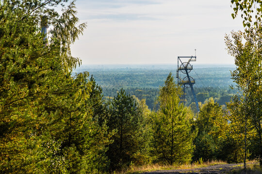 Steel headframe of an abandoned coal mine  among trees. Kostuchna, Katowice, Silesia, Poland