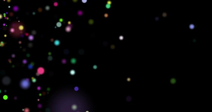 Colorful particles floating slowly over dark background, abstract magical multicolored stardust or confetti, footage